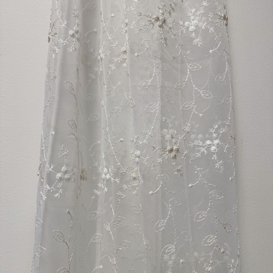 Tüllkardinakangas valge,  valge- beežikirju tikandiga. Aluäär sakiline, kõrgus 300cm;