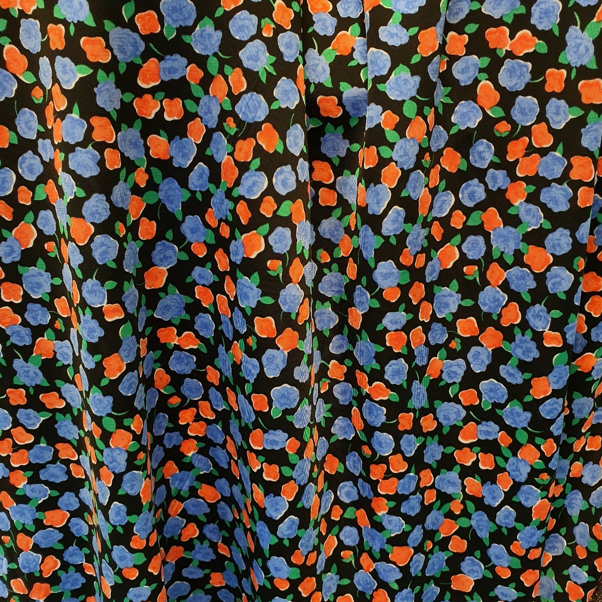 Viskoostrikotaaz siidine, mustal sinised ja oranzid väikesed lilled, laius 136cm.